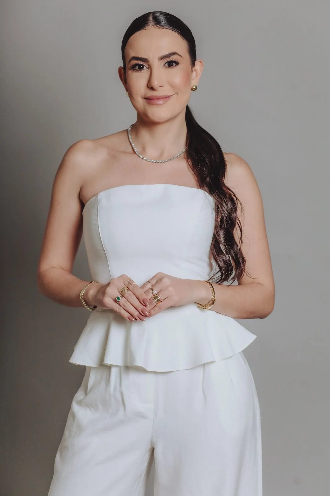 Camila Freitas sorrindo, vestida de branco